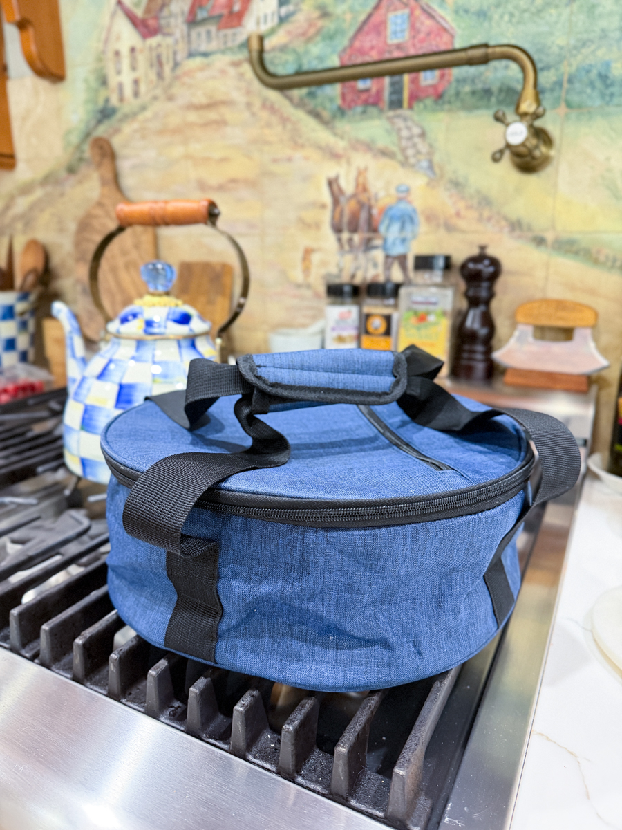 Blue insulated casserole carrier sitting on stovetop in kitchen