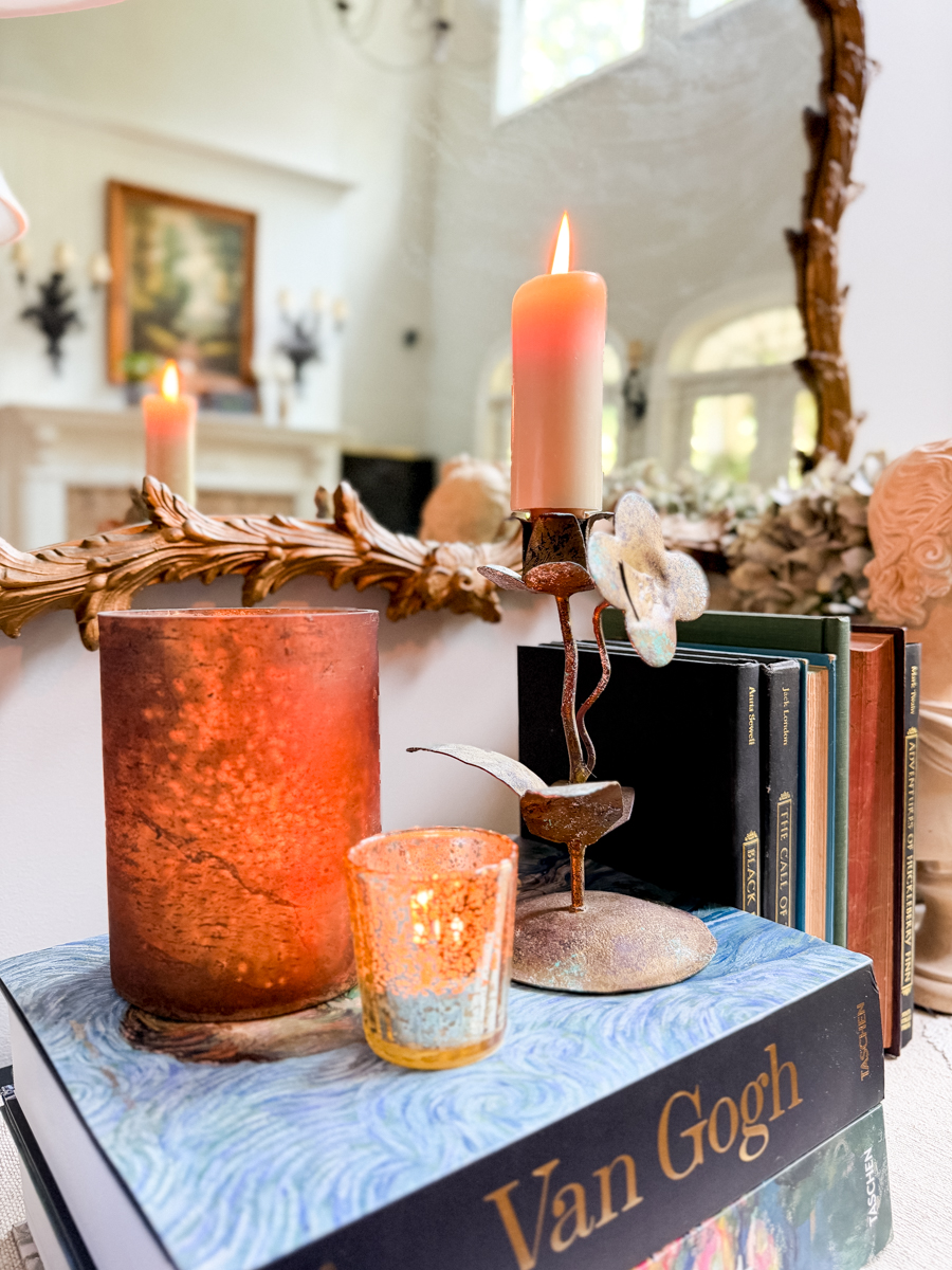 Vintage art books, amber candleholders, aged metal decor, classical bust, and warm-colored books for early fall.