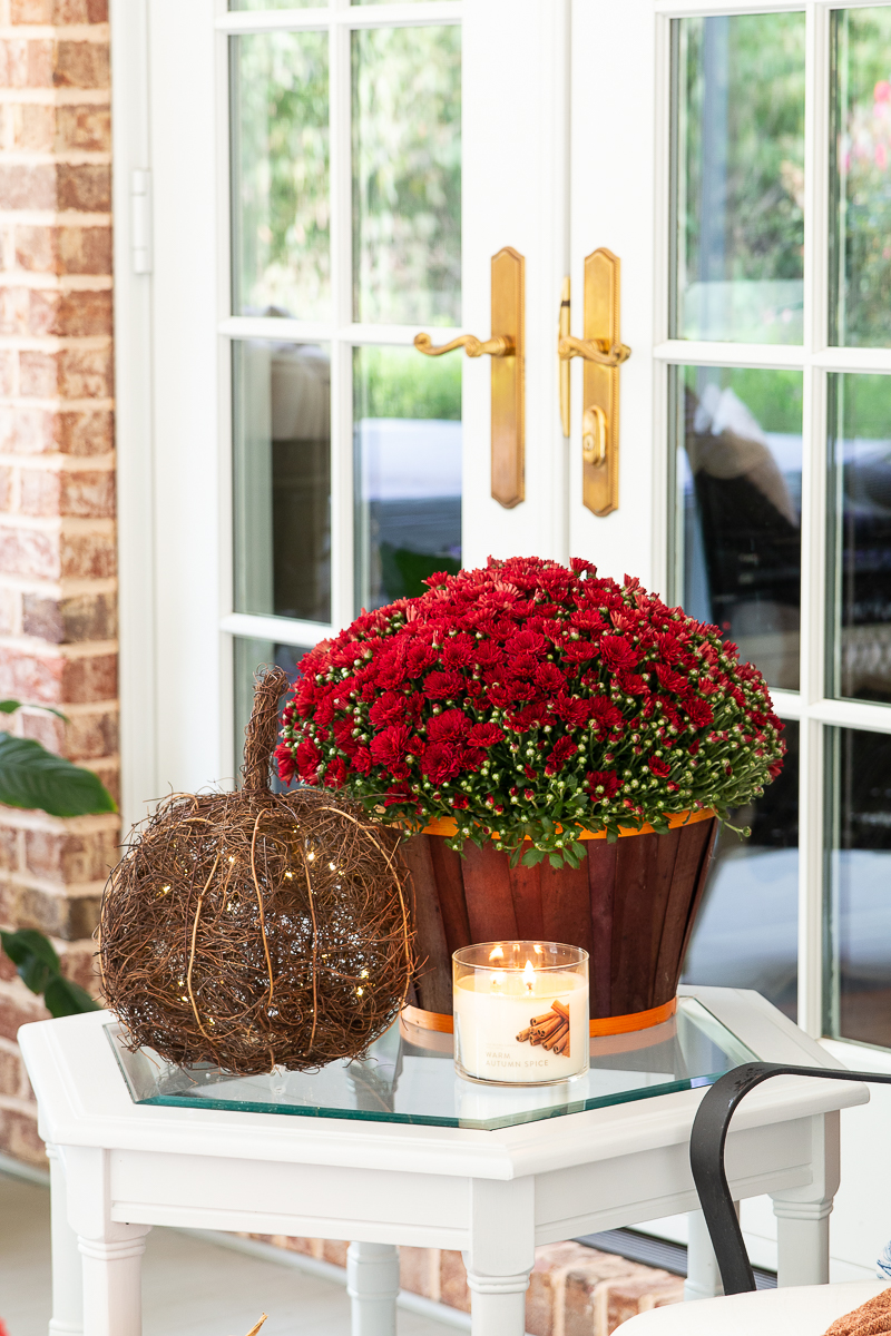 fall porch with mums, pumpkins and candle