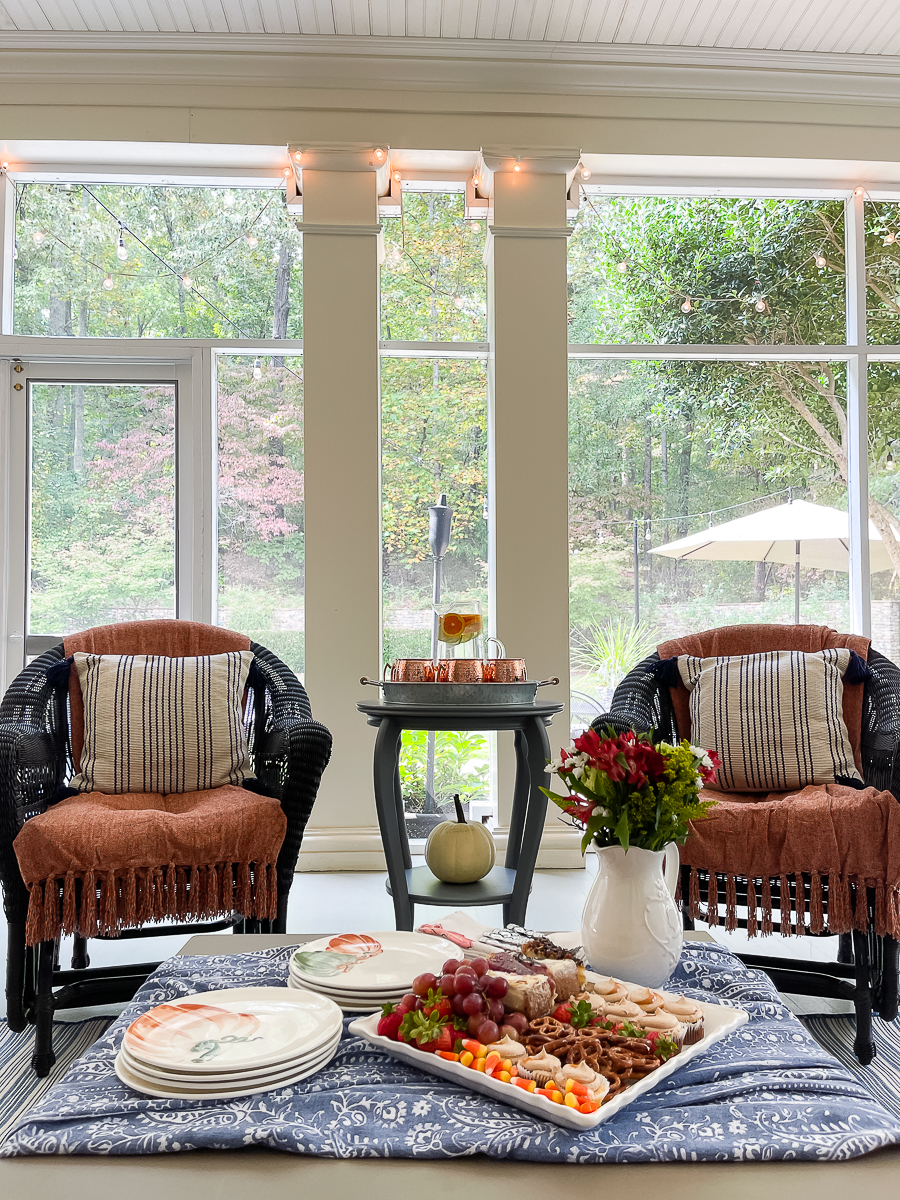 porch decorated for fall with 2 chairs