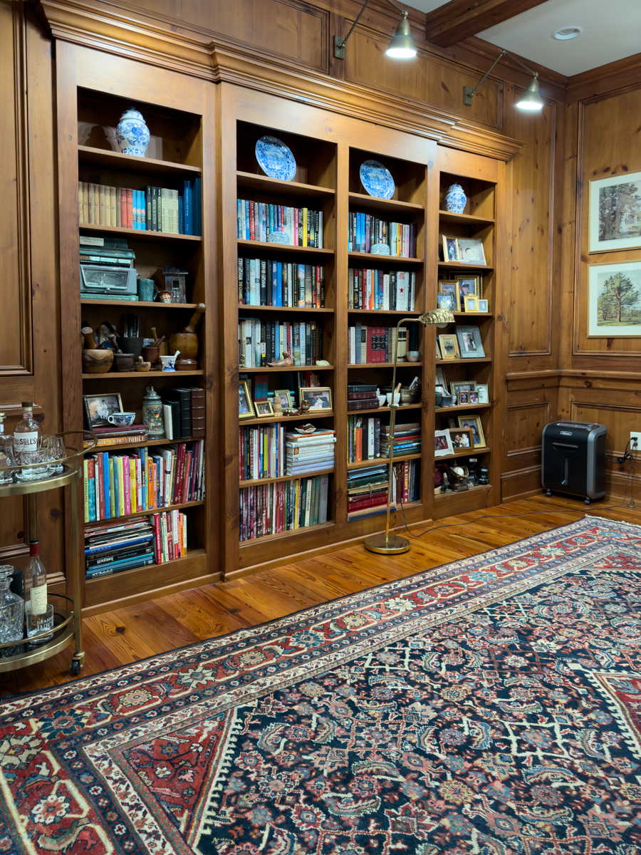 Built-in wood bookcases filled with books, family photos, and blue and white decor