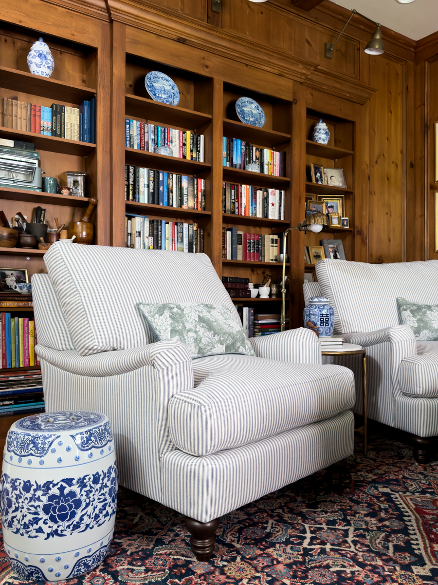 Striped upholstered chair with green toile pillow and blue and white ceramic garden stool