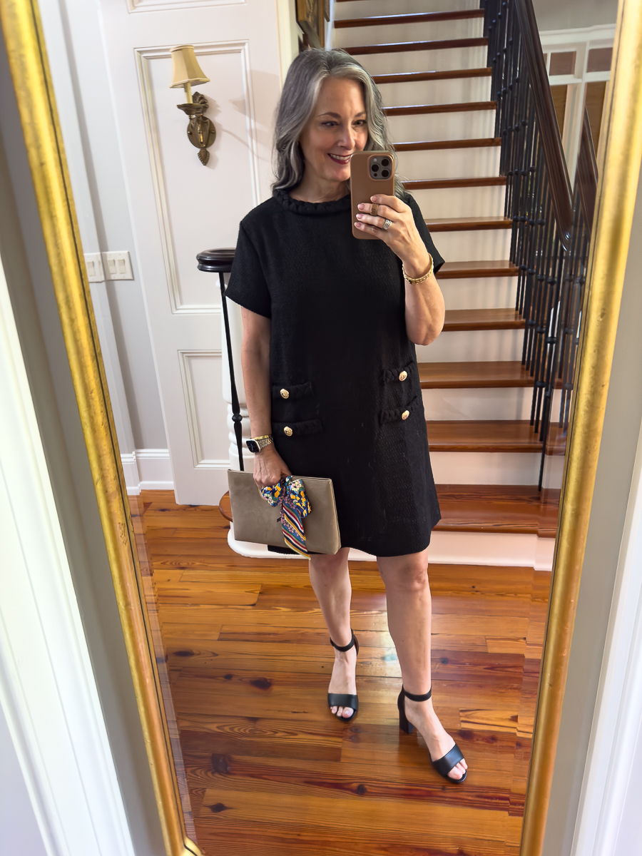 Woman wearing a black tweed dress with gold button detail styled for church outfit inspiration.