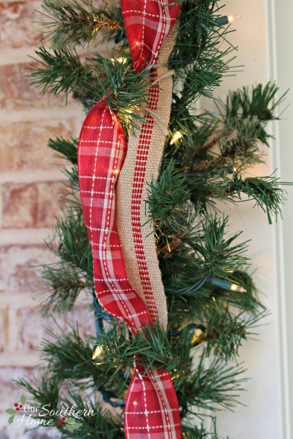 Plaid ribbon and upholstery ticking trim the door / Christmas Front Porch / www.oursouthernhomesc.com