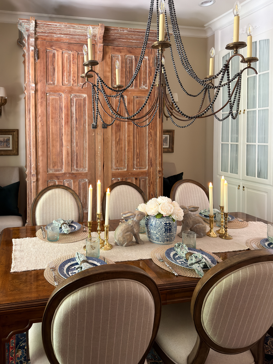 dining table with blue and white china, brass candlesticks, bunnies, and flowers