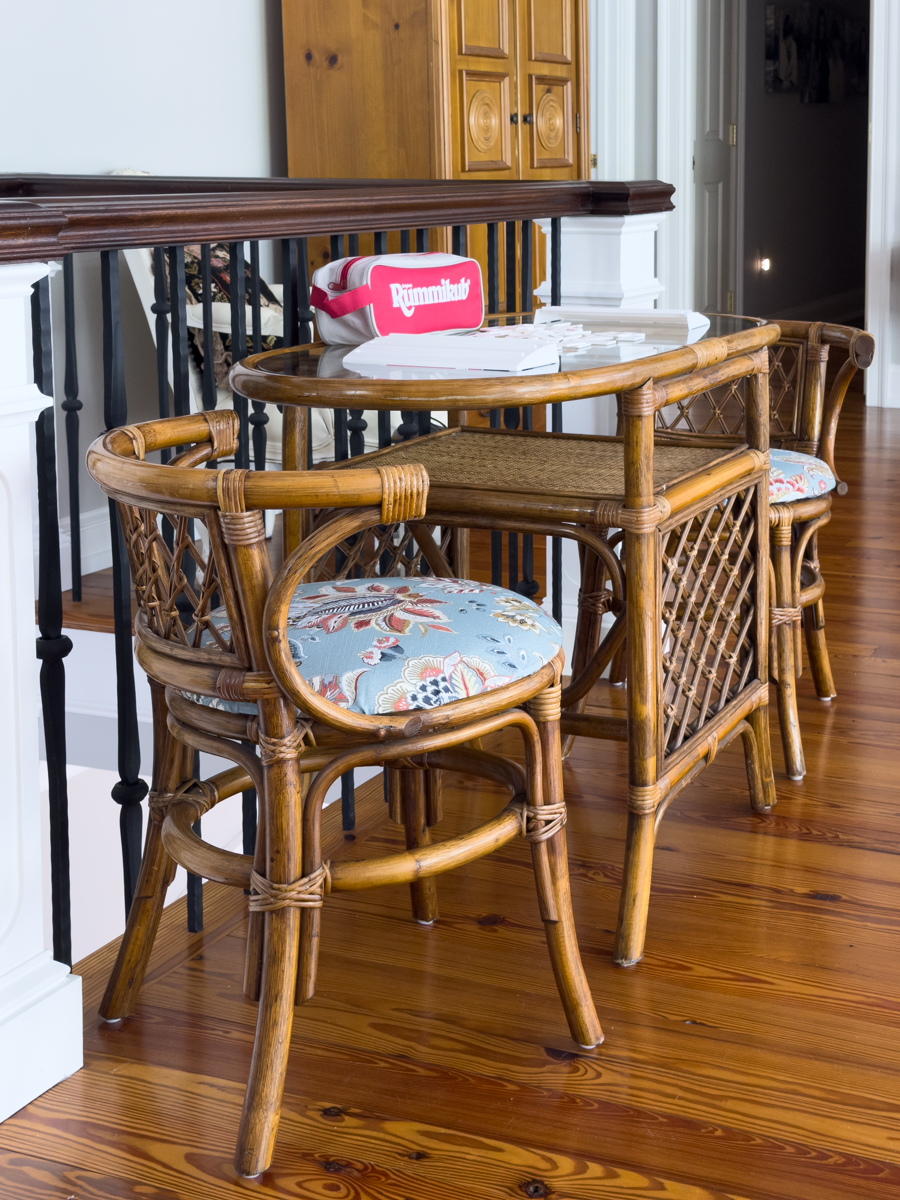 Rattan table with floral upholstered chairs and a Rummikub game ready to play.