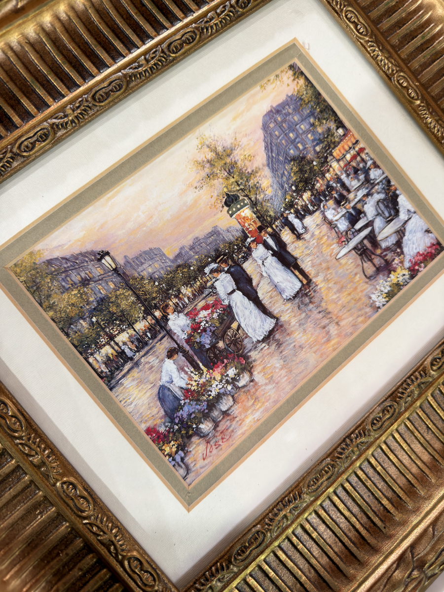 Closeup of vintage Paris street print in ornate gold thrift store frame