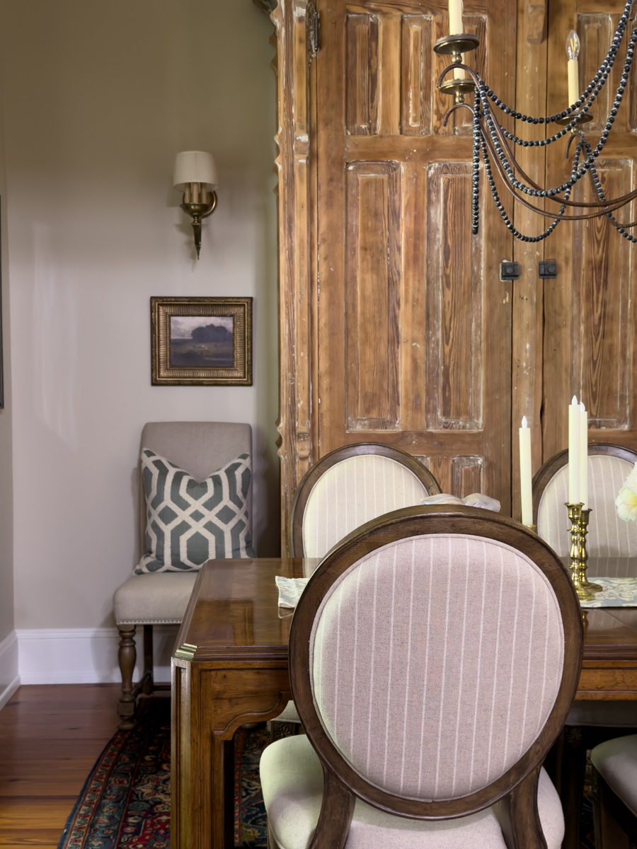 Dining room styled with vintage gold framed landscape art and layered decor