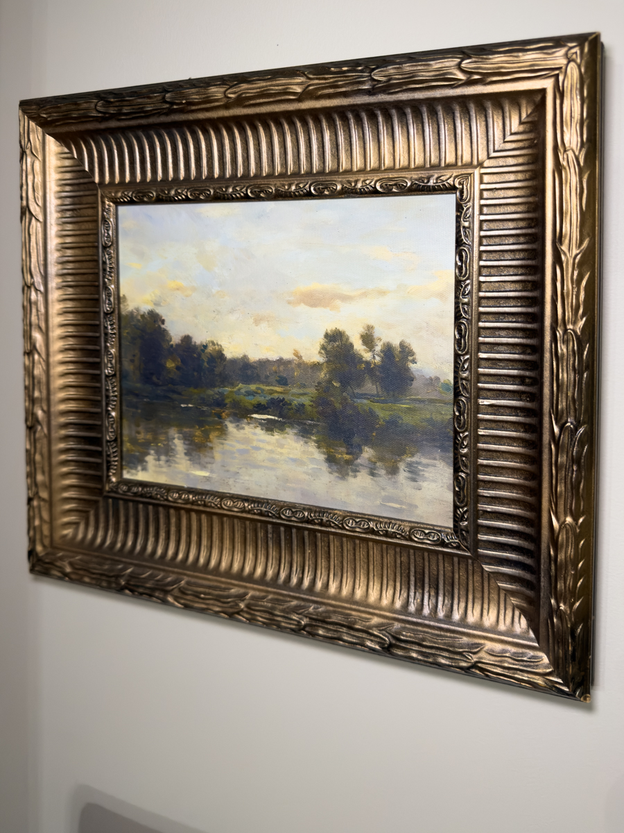 Moody landscape art displayed inside ornate vintage gold frame