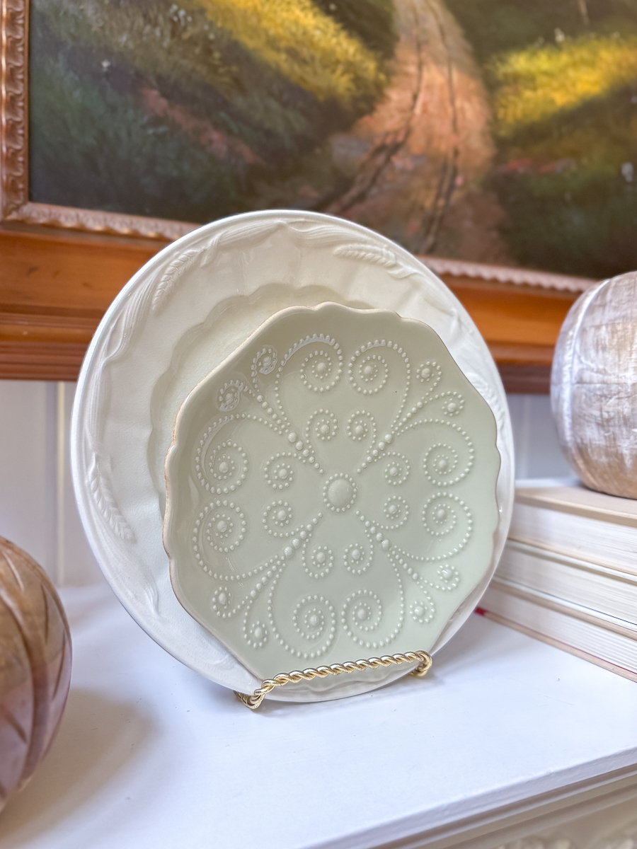 Decorative plates stacked together on a white mantel.