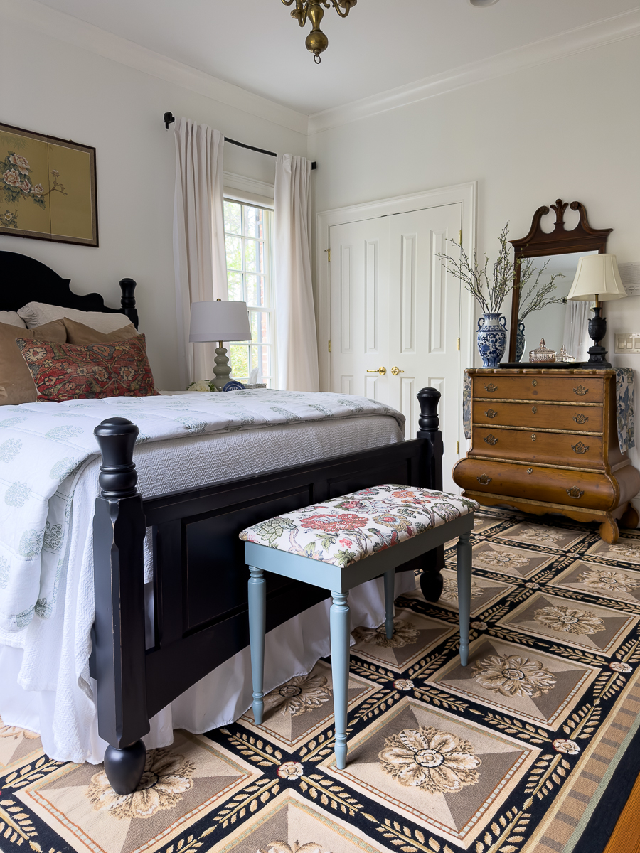 styled piano bench with floral cushion in home interior