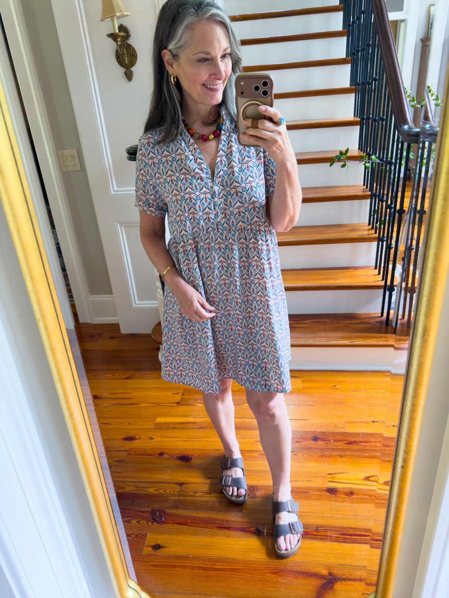 Woman wearing a printed shirt dress styled with Birkenstock sandals for summer travel