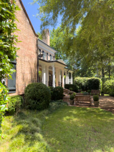 Traditional Southern brick home with courtyard seating and manicured landscaping