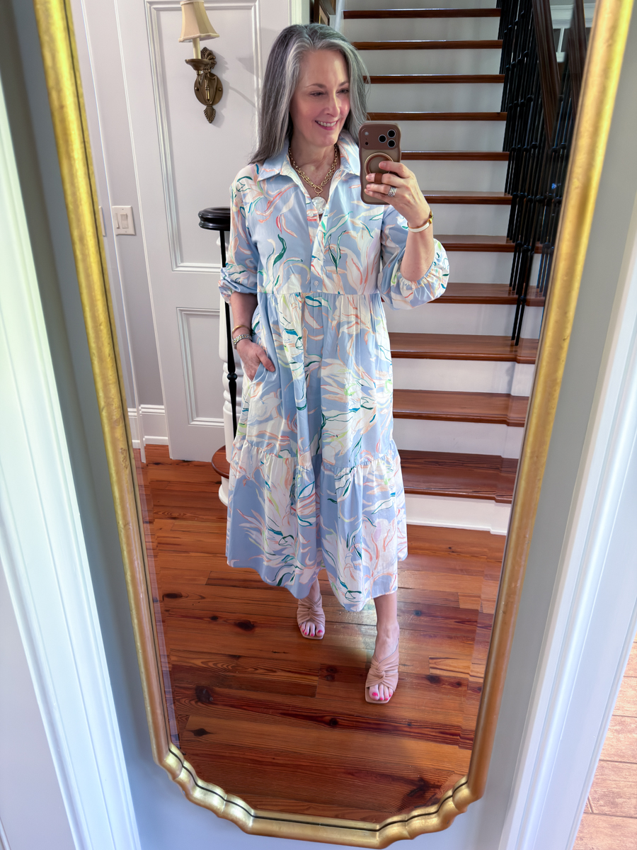 Woman wearing a blue and white floral midi dress with woven flats in mirror selfie