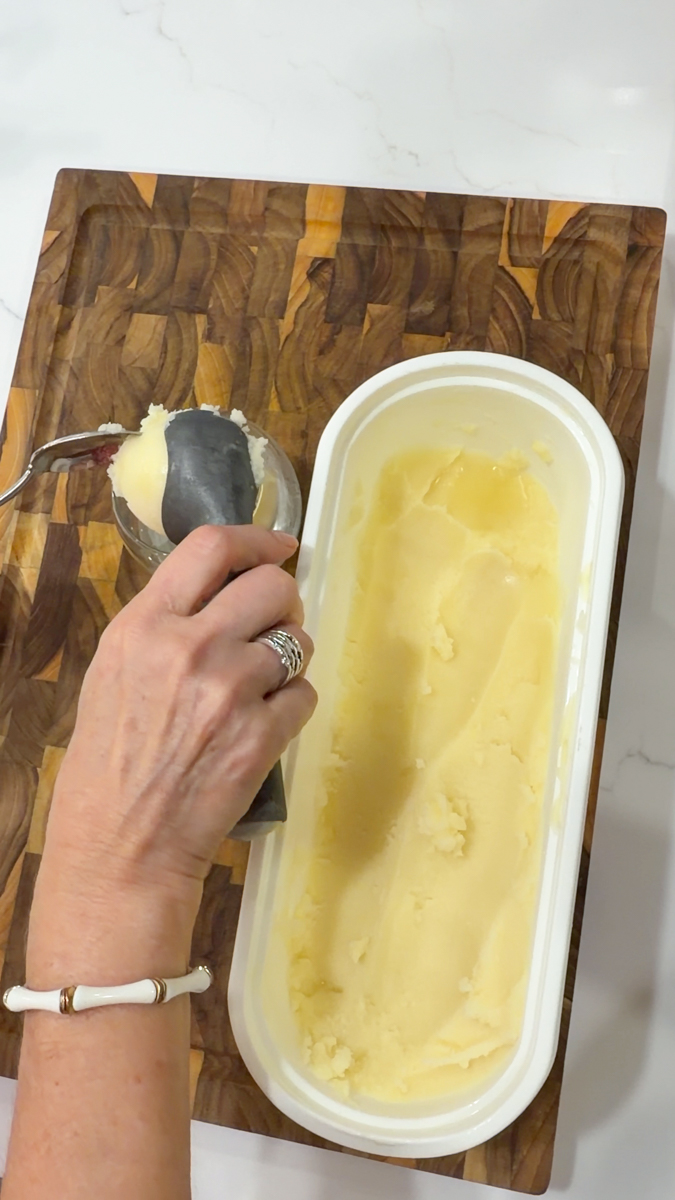 Scooping frozen piña colada into a serving glass.