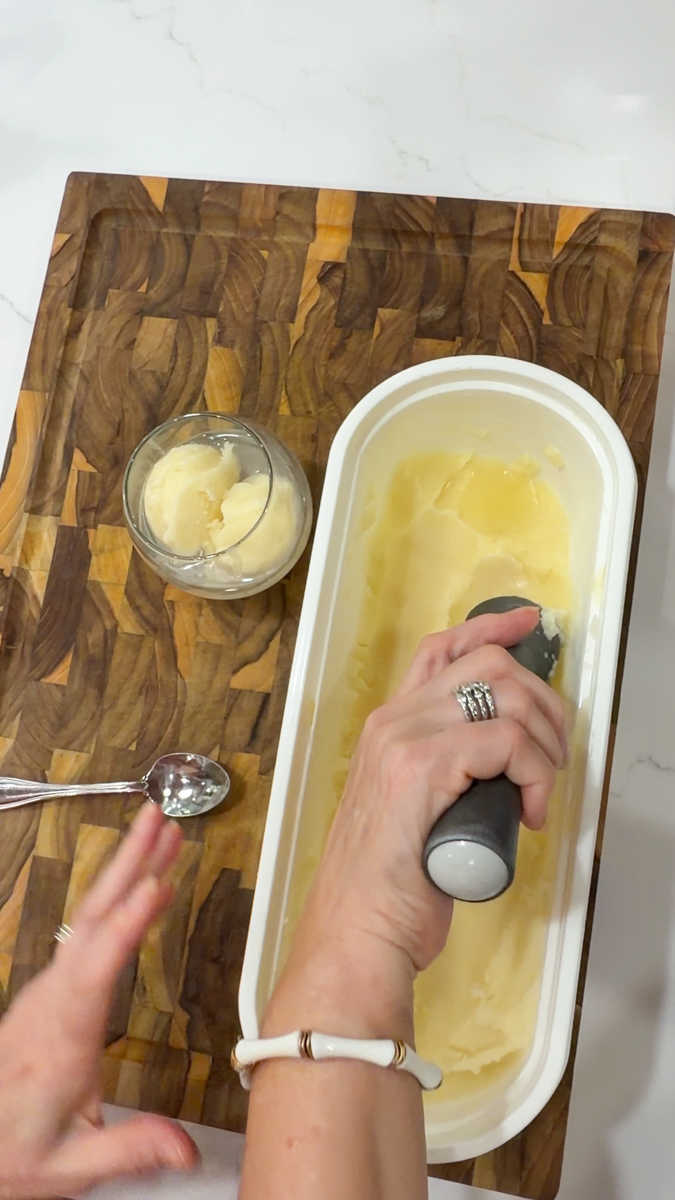 Scooping frozen piña colada into a serving glass.
