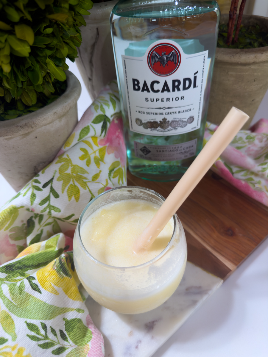 Stirring white rum into a homemade frozen piña colada.