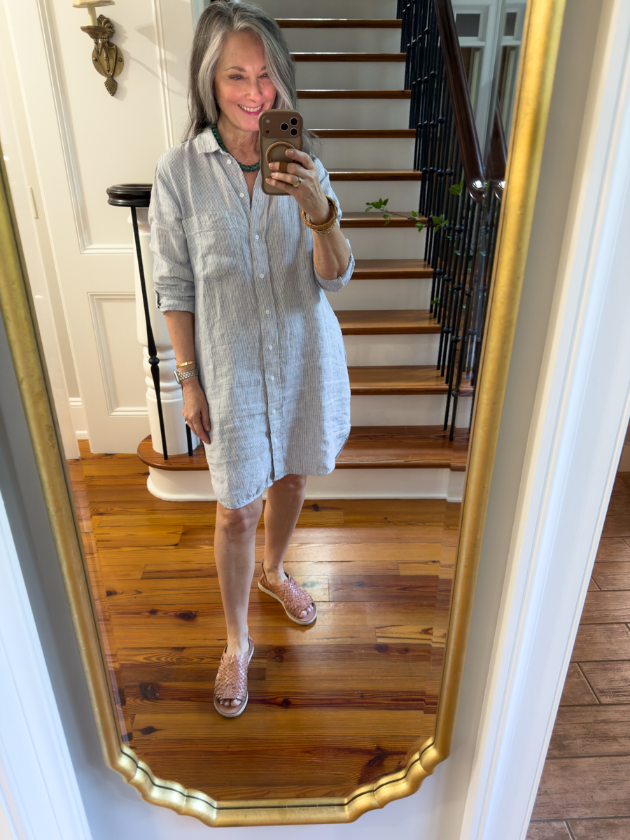 Woman wearing a striped linen shirt dress with woven sandals for summer