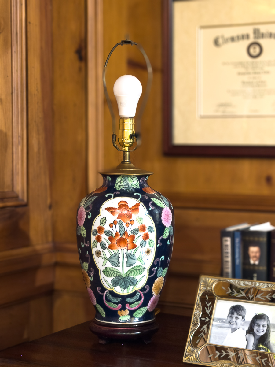 Vintage Facebook Marketplace lamp with block‑print shade styled on a wood desk in a pine‑paneled study