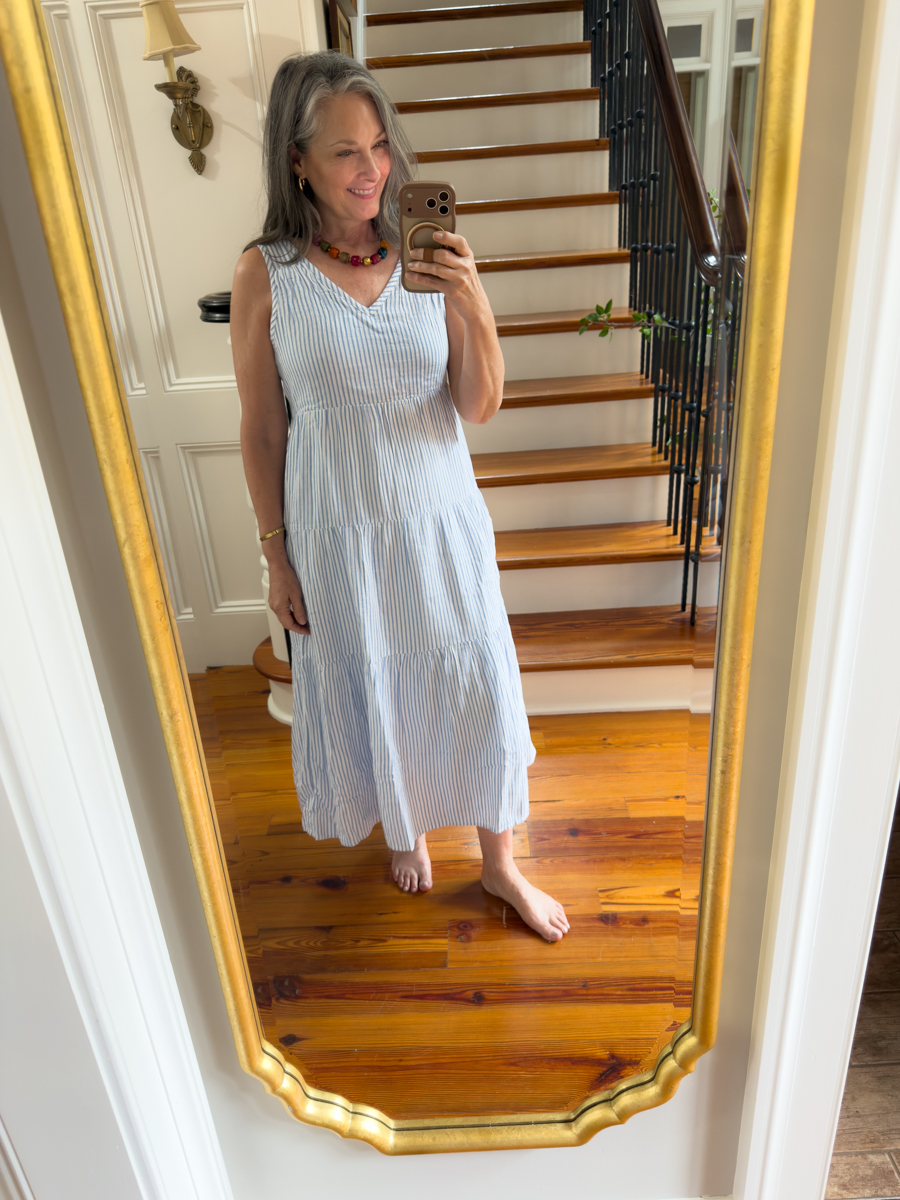 Woman wearing a blue and white striped gauze midi dress for summer style