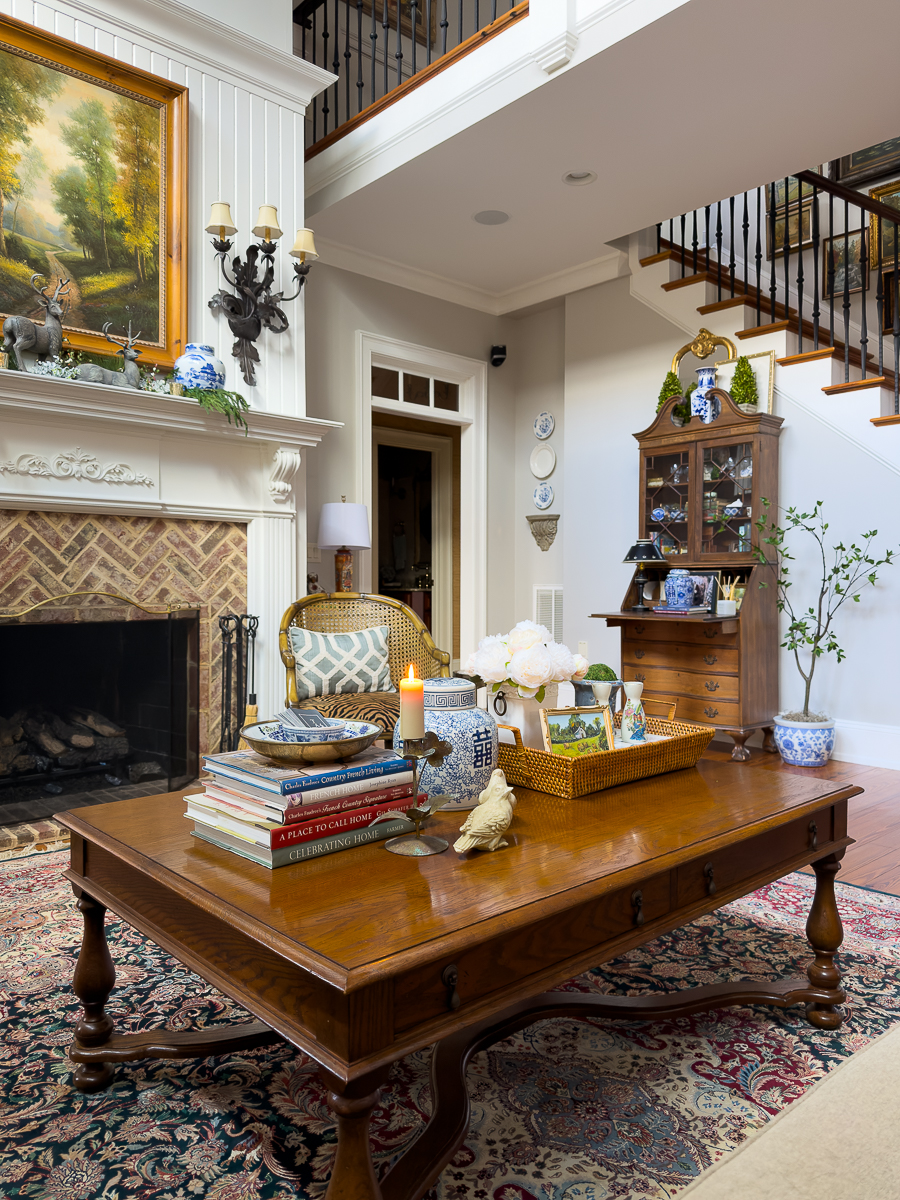 Classic wooden coffee table styled with thrifted decor in a traditional living room.