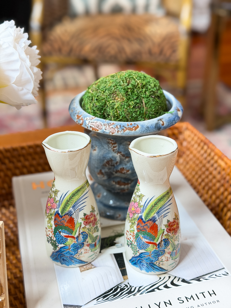 Decorative moss ball placed in a vintage planter on a coffee table vignette.