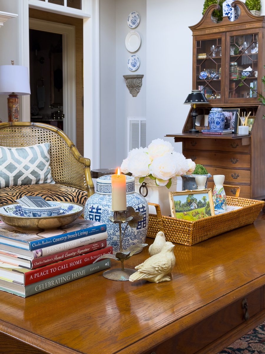 Living room coffee table styled with vintage decor, books, flowers, and thrifted accessories.