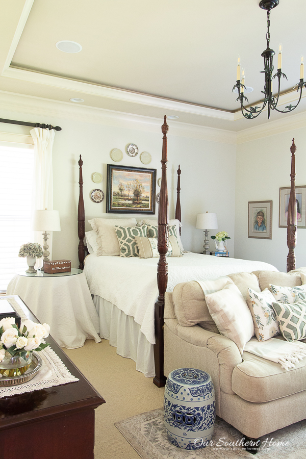 Gray master bedroom decorated for summer with blues and greens with a rice bed