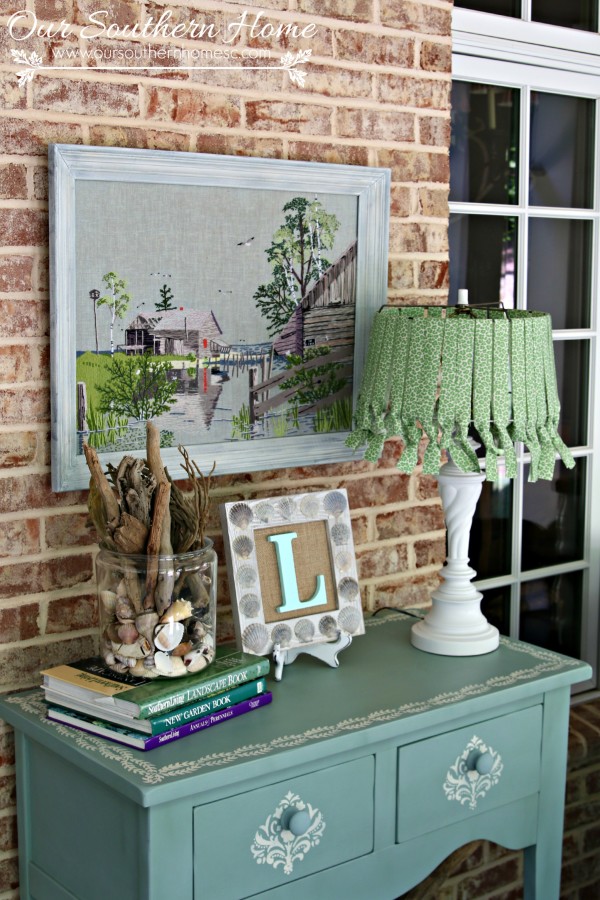 Thrift store needlework art become a showpiece on the screened porch with a new finish to the frame.