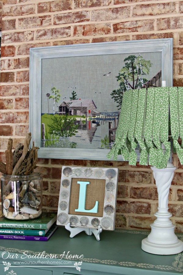 Thrift store needlework art become a showpiece on the screened porch with a new finish to the frame.