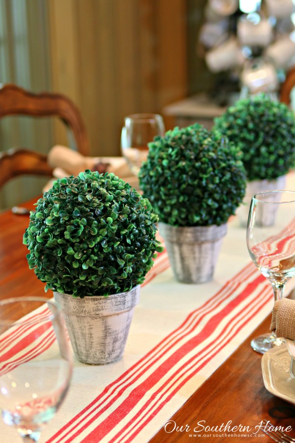 Make an inexpensive centerpiece by applying a weathered paint treatment to clay pots to create a striking topiary by Our Southern Home