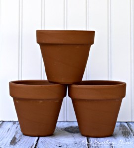 Make an inexpensive centerpiece by applying a weathered paint treatment to clay pots to create a striking topiary by Our Southern Home