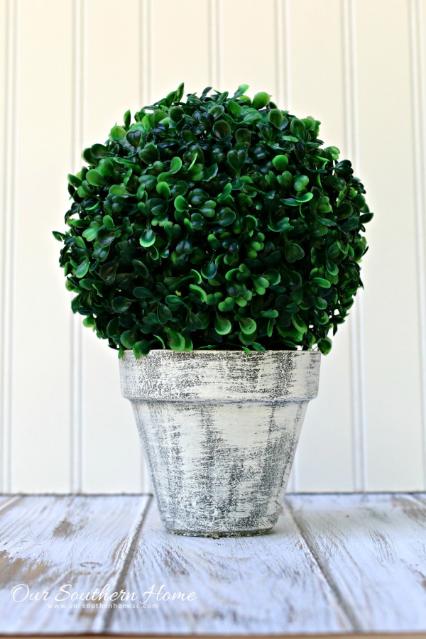 Make an inexpensive centerpiece by applying a weathered paint treatment to clay pots to create a striking topiary by Our Southern Home