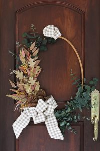 Thrift store makeover with an embroidery hoop! Make this wreath in no time using only wire, florals and ribbon. #fallwreath #thriftstore #wreath #embroideryhoop