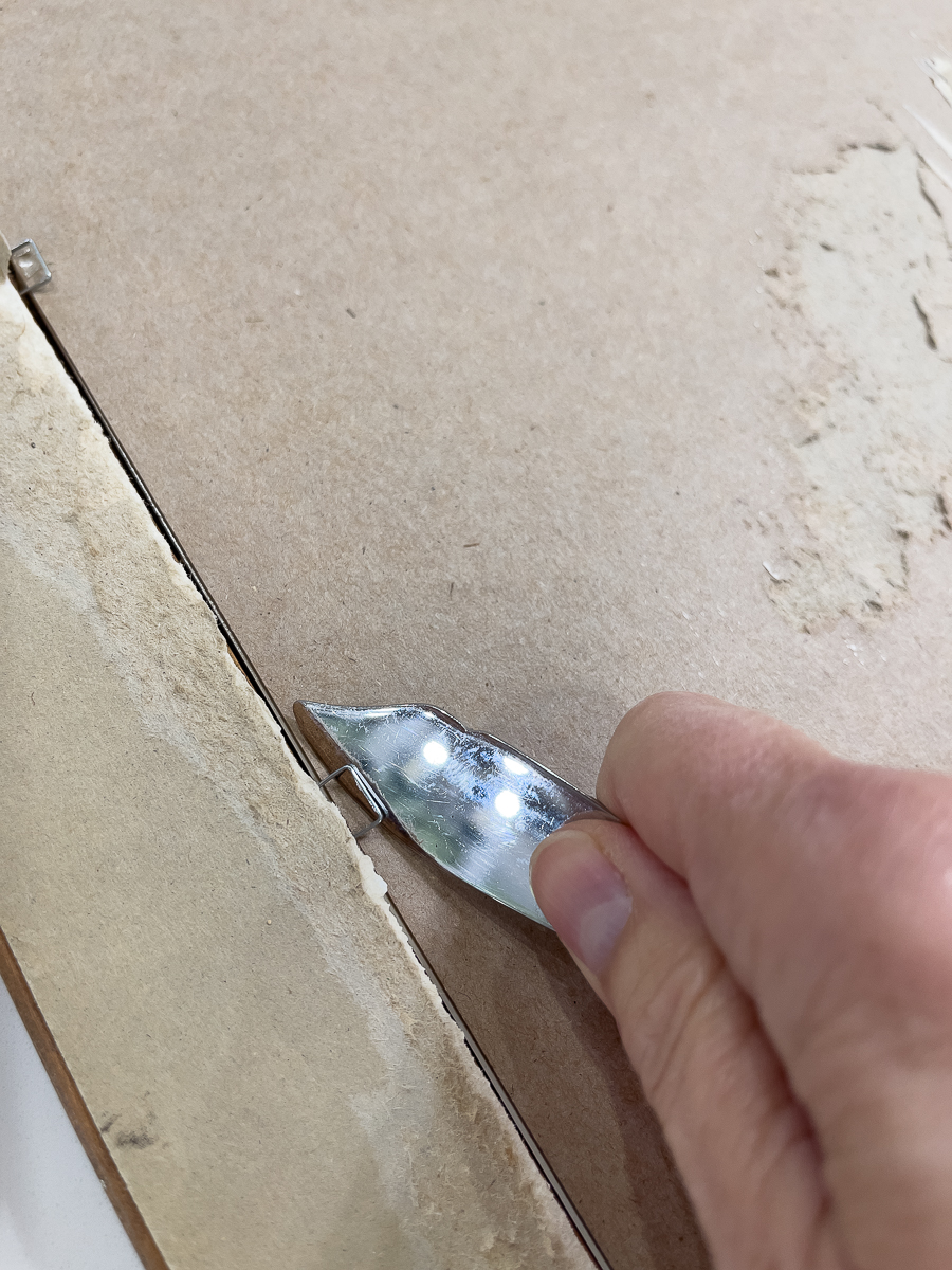 removing frame staples with butter knife