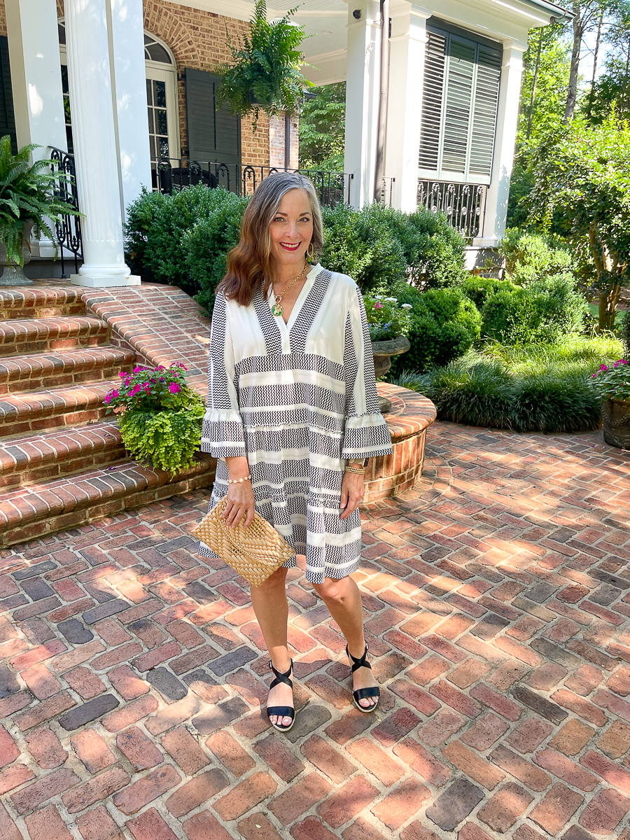 woman in black and white dress holding purse