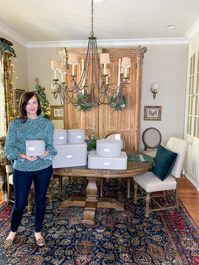 dining room with woman holding storage crates