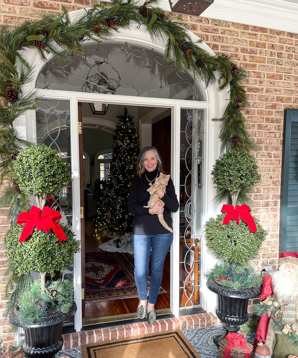 woman holding kitten on Christmas porch