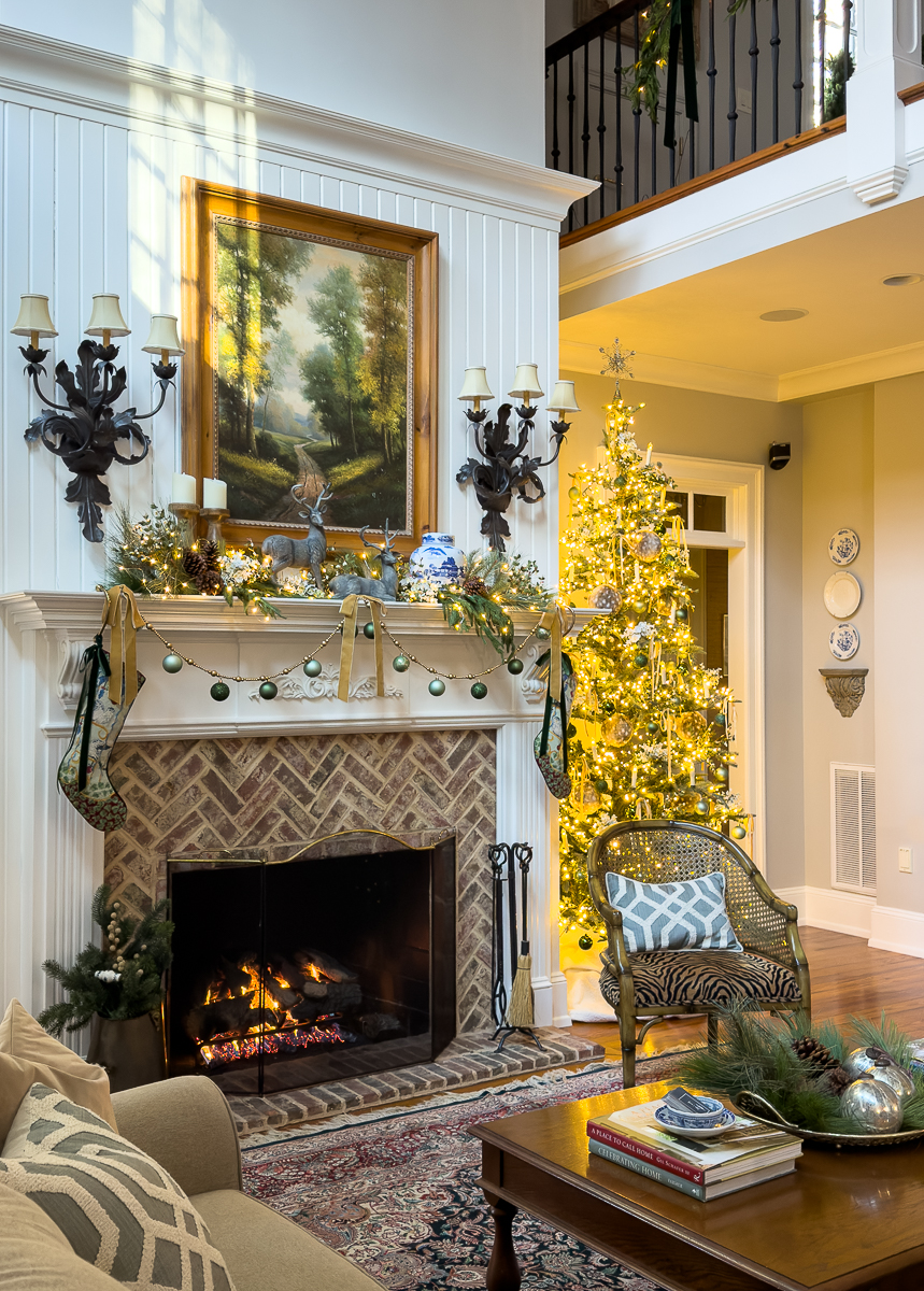 christmas tree beside a mantel with fire roaring