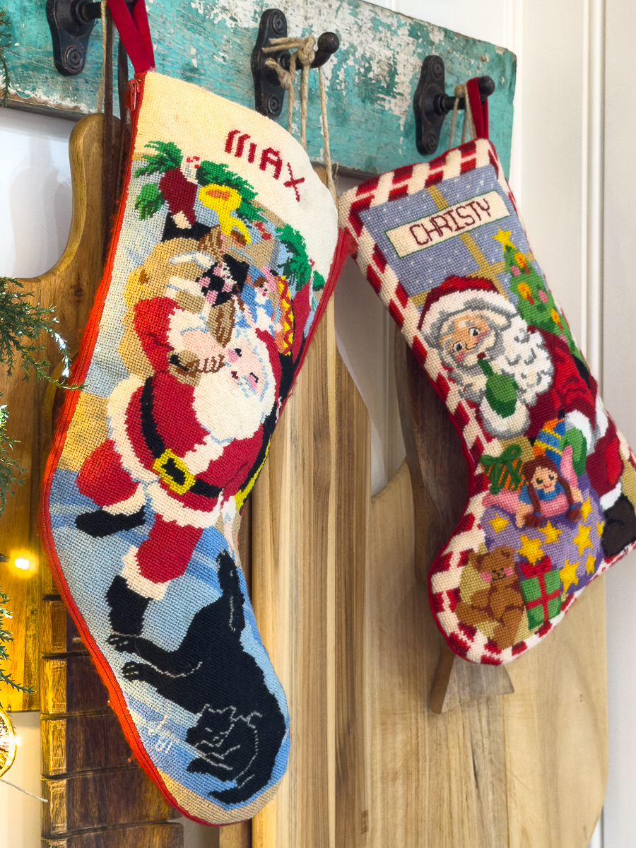 pair of 2 cross-stitch stockings hanging on the wall with cutting boards
