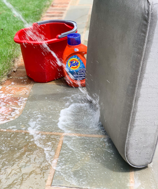 spraying off outdoor cushions