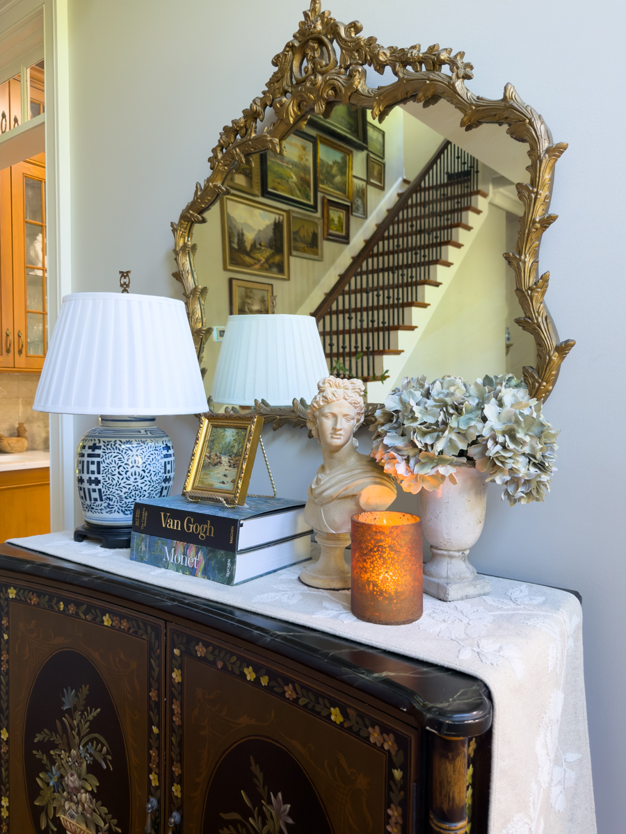 Blue and white ginger jar lamp styled with art books and a small gold frame