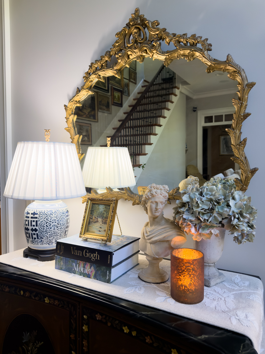Blue and white ginger jar lamp glowing beside hydrangeas and traditional decor