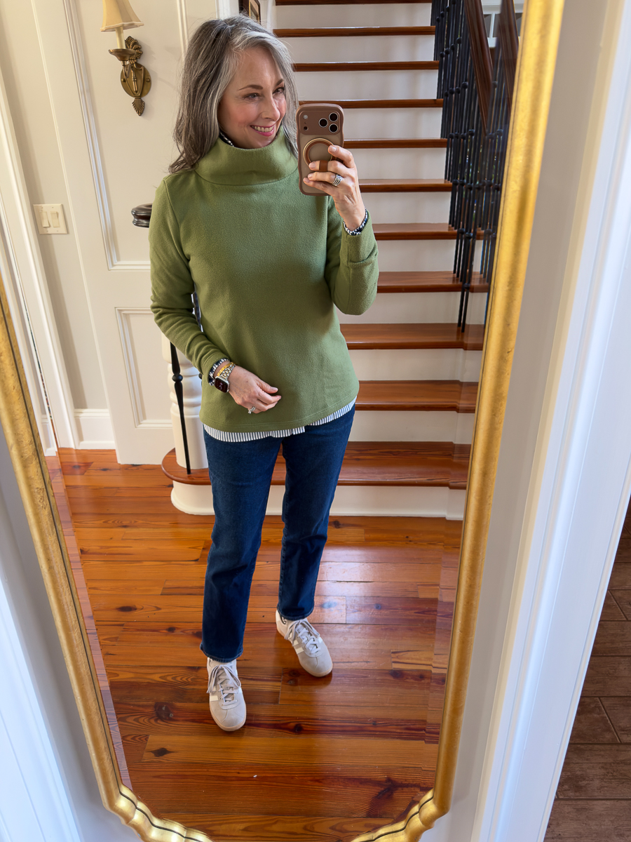 Woman wearing a green Dudley Stephens fleece styled casually at home during winter
