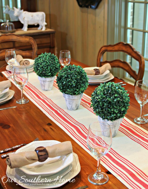 Make an inexpensive centerpiece by applying  a weathered paint treatment to clay pots to create a striking topiary by Our Southern Home