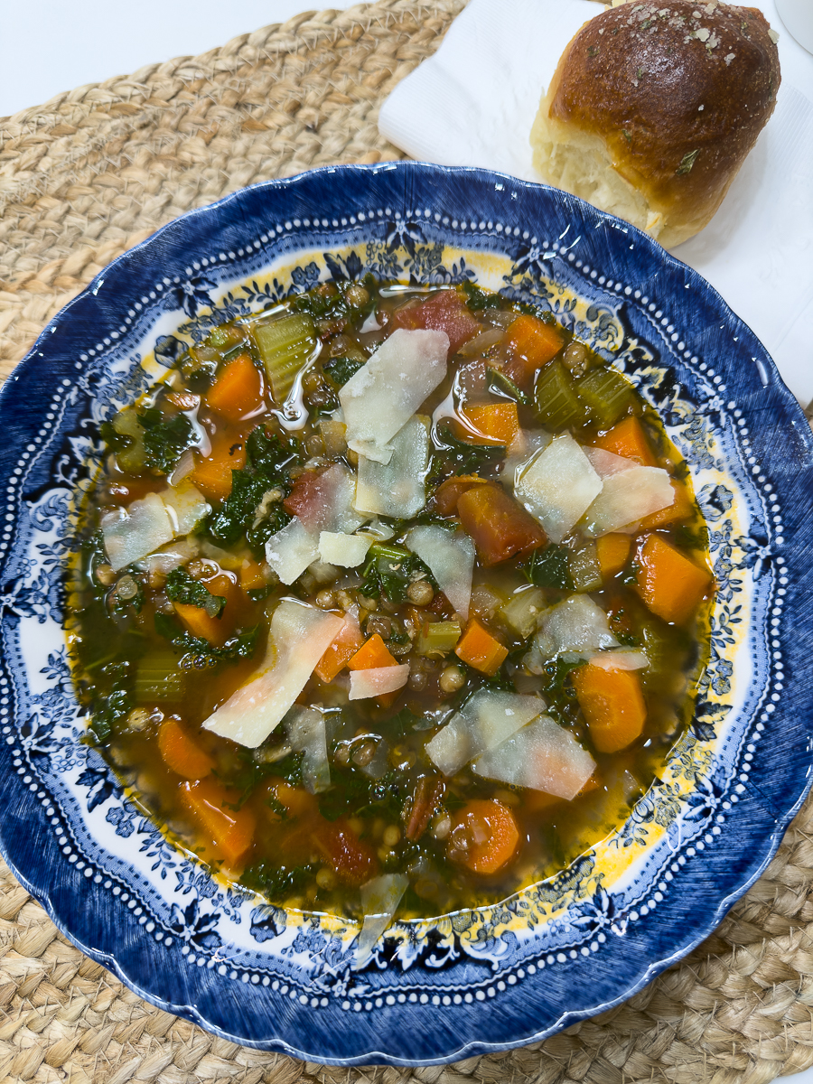 Bowl of lentil soup topped with parmesan cheese in a white bowl.
