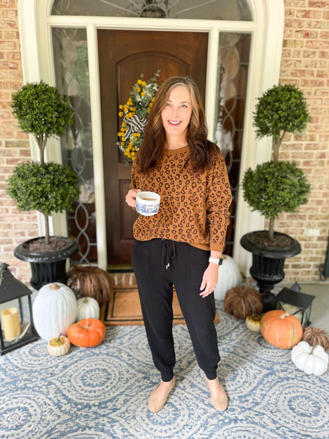 woman on porch dressed in leopard sweatshirt and joggers