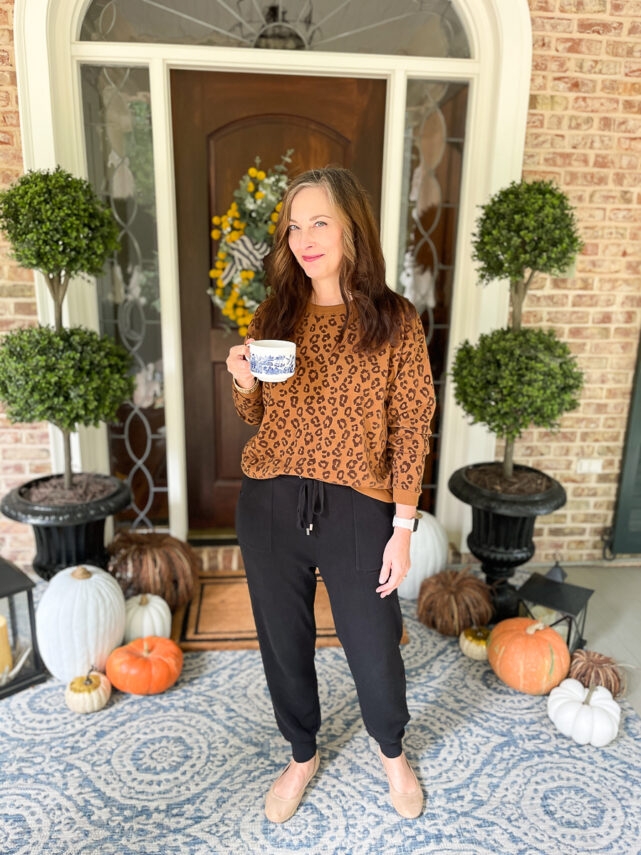 woman on porch dressed in leopard sweatshirt and joggers