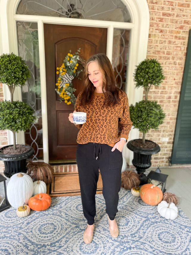 woman on porch dressed in leopard sweatshirt and joggers