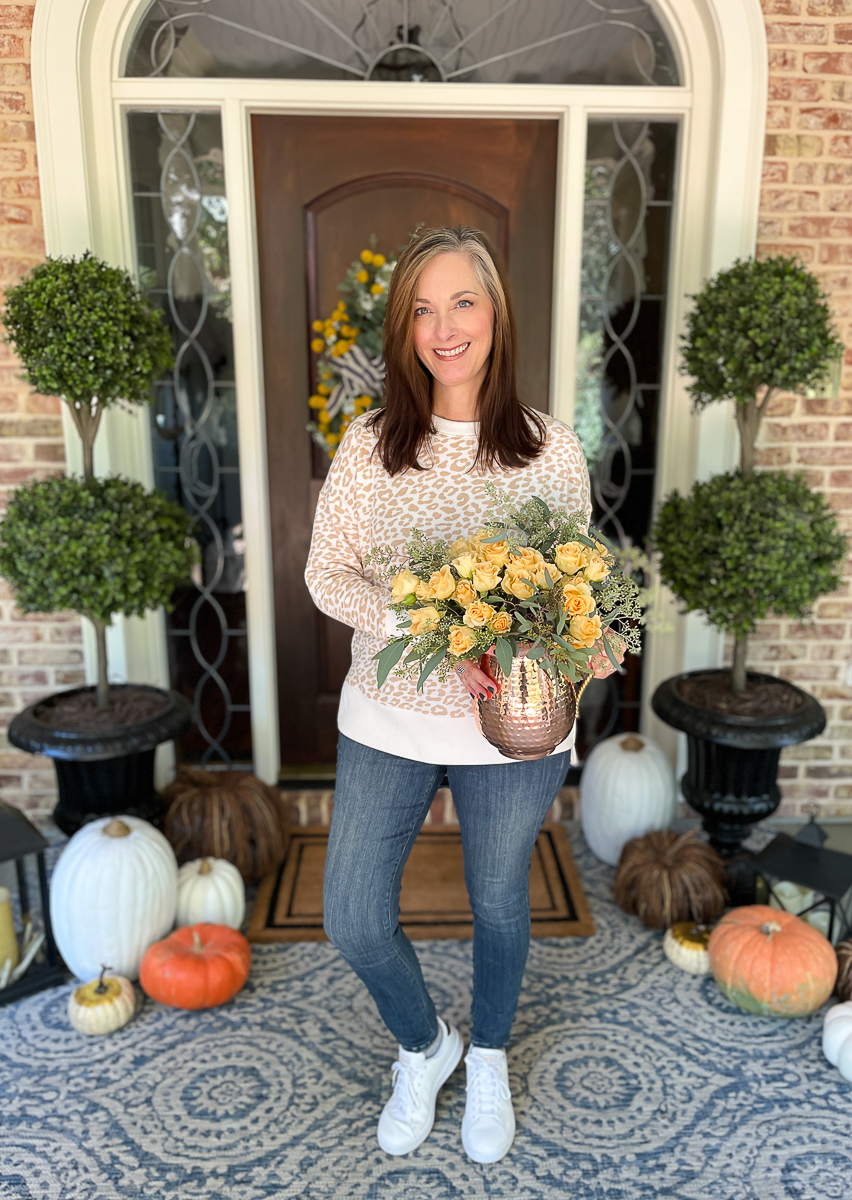 woman on porch holding flowers